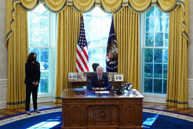 US President Joe Biden, with Vice President Kamala Harris (L), speaks before signing executive orders on health care in the Oval Office
