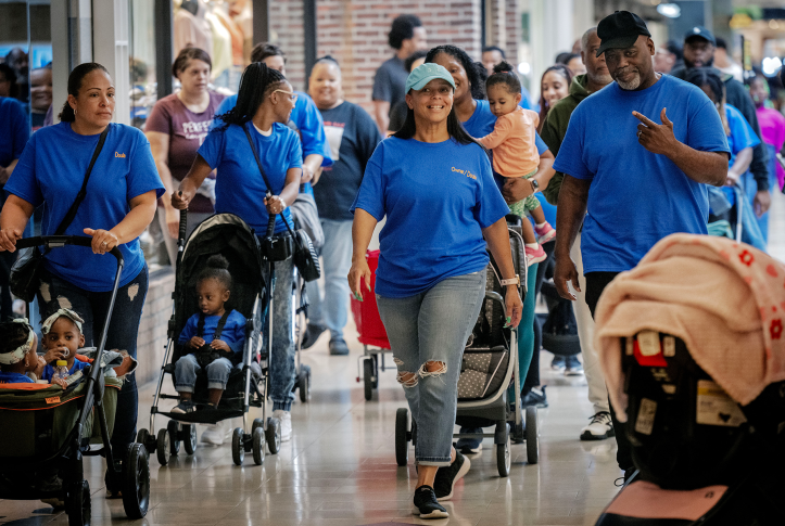 Photo, families wearing blue shirts on a stroller walk in the mall