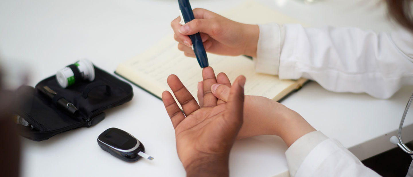 doctor testing blood of diabetes patient