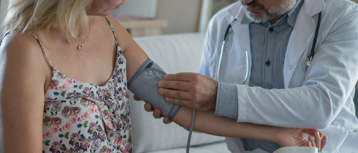 doctor taking patient's blood pressure