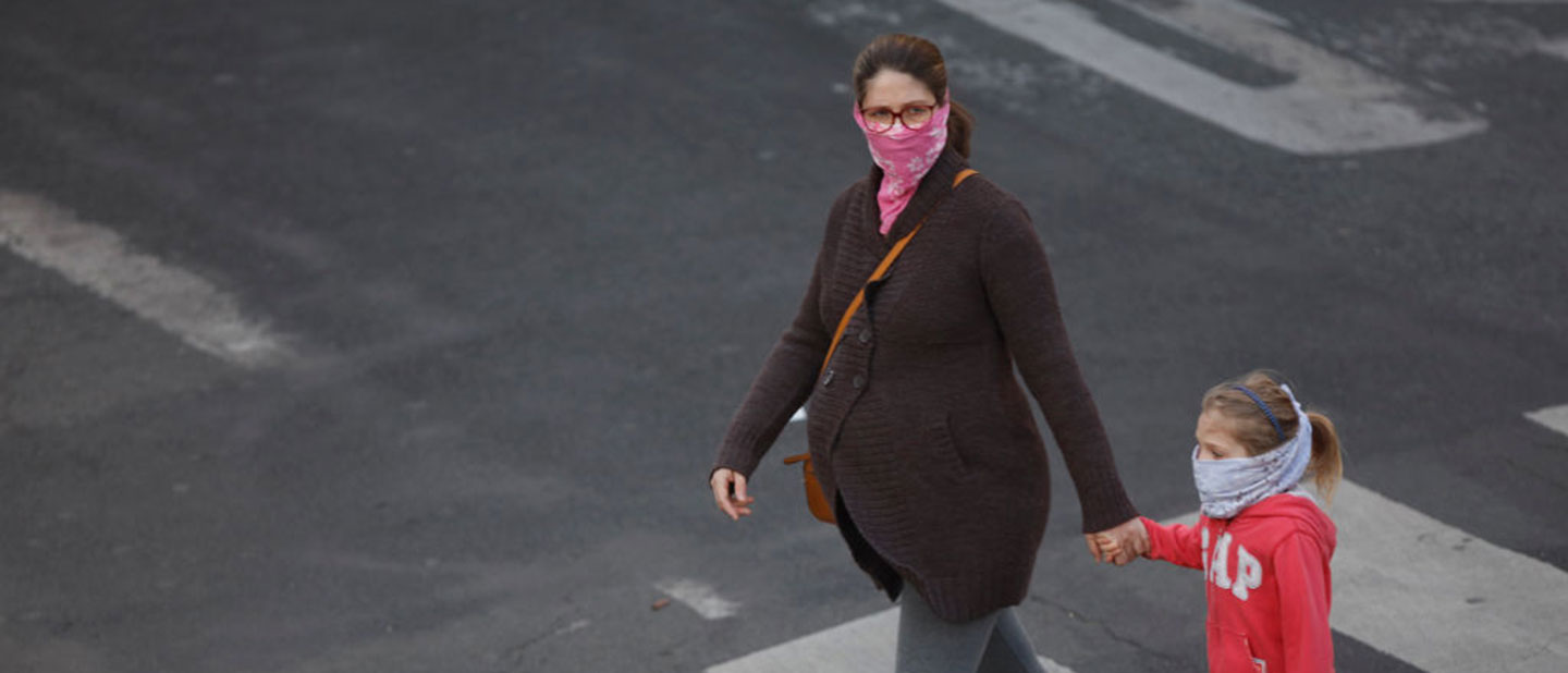 pregnant woman walking with child and masks during COVID-19 outbreak