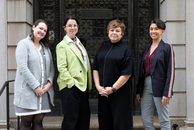 Four women posing for a photo standing in front of the Commonwealth Fund building