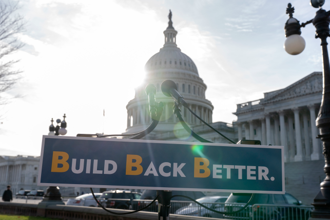 Build Back Better sign sits in front of capitol building for press conference