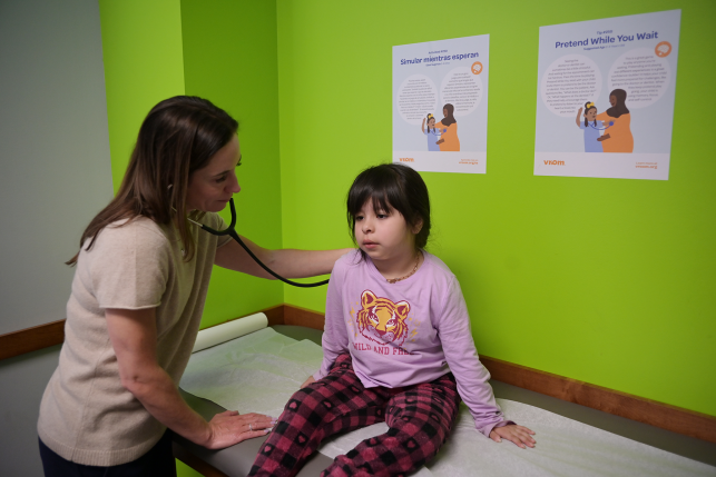 Doctor examines young girl on medical bed