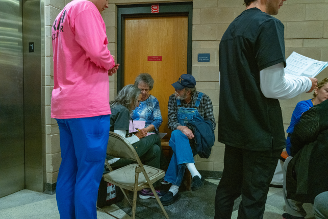 People sit in folding chairs