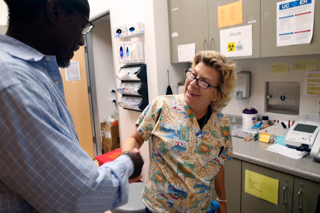 Nurse shakes hand with patient in doctors office