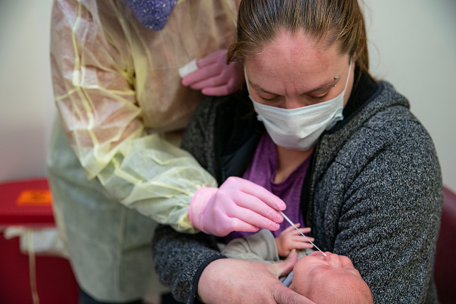 Beth Thomsen, M.L.S., administers a nasal swab to two-month-old Eden Smith to test for the flu at the Min No Aya Win clinic on the Fond Du Lac reservation in northern Minnesota.