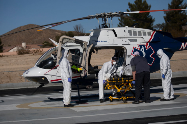 Medical workers load patient onto emergency ambulance