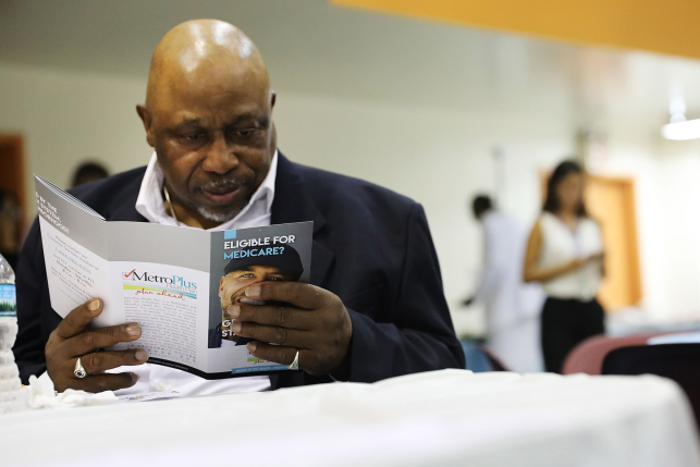 James Cammick reads literature on Medicare at a Senior Citizens Prom sponsored by the MetroPlus, a prepaid health services plan, on June 23, 2017 in New York City. 