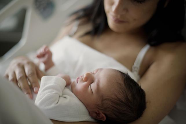 Mom holding sleeping newborn baby