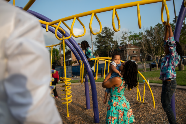 Shell Reed plays with her children on a playscape at Cuney Homes in Houston’s Third Ward 