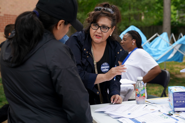 Photo, specialist helping pregnant woman fill out Medicaid insurance paperwork