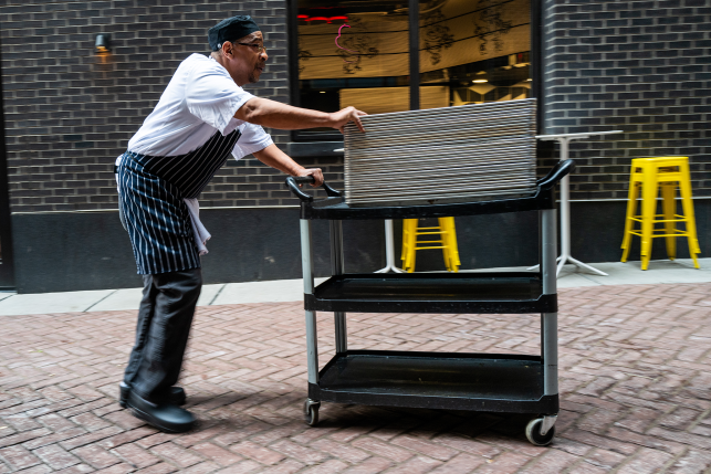 Man in apron pushes cart