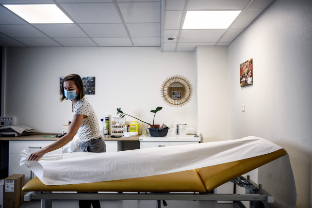 Doctor spreads out a sheet on a hospital bed