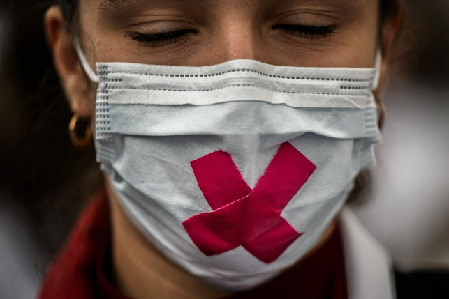 Photo, woman with closed eyes in mask with red cross over mouth