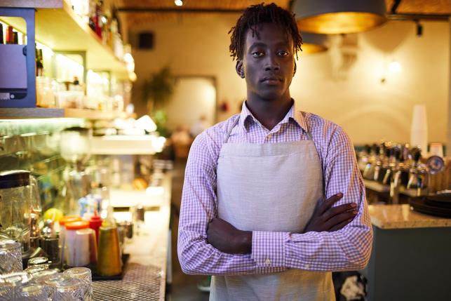 Restaurant worker in an apron at his place of employment.