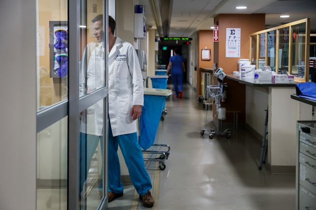 Photo, doctor looks inside room in ER