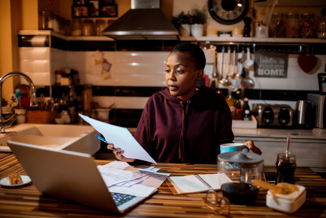 woman looks at paperwork in kitchen