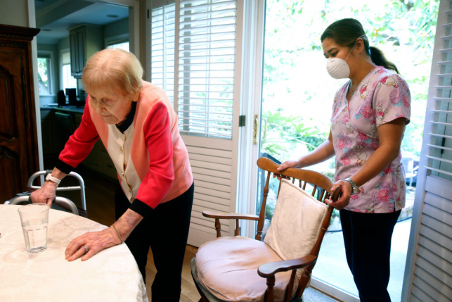 Home health aide helps patient in their home