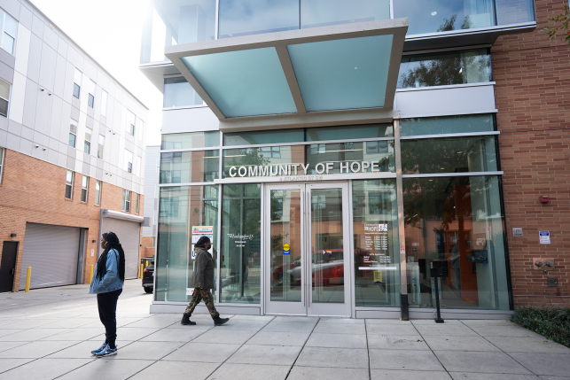 Pregnant patients walk in front of community health center entrance