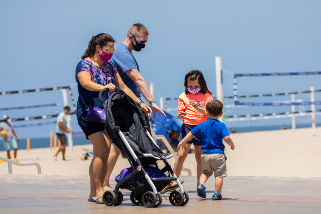 A family walks near Hermosa Plaza at the beach in Hermosa Beach, CA.