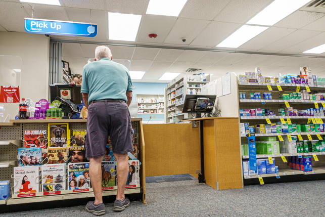 Photo, back of man at drug store counter