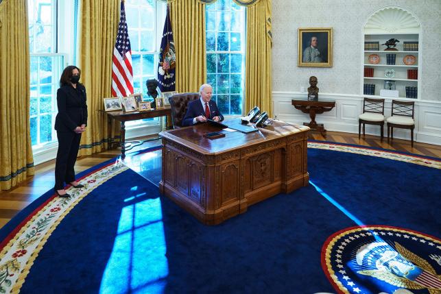 President Joe Biden, with Vice President Kamala Harris (left), signs executive orders on health care, including reopening enrollment in the Affordable Care Act. The Biden administration has pledged to expand coverage and help improve affordability under the ACA.