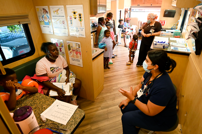 Nurse discusses asthma screening with patient in mobile clinic