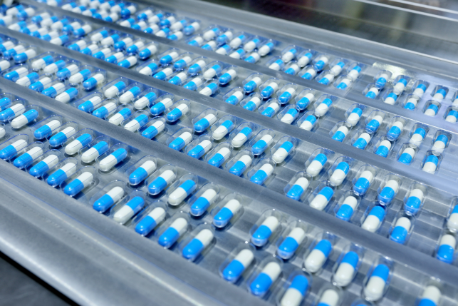 white and blue capsule pills in a row