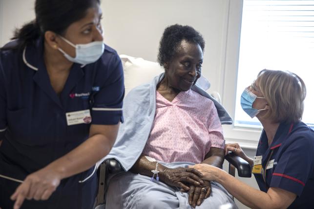 Elderly Black woman receives COVID-19 vaccine at NHS facility