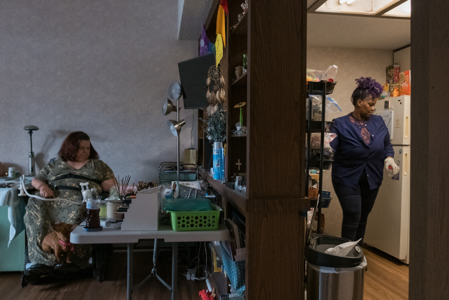 Caregiver in kitchen helps woman with disabilities