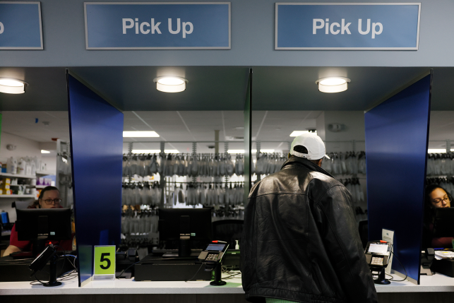 Man stands in front of pharmacy pickup window