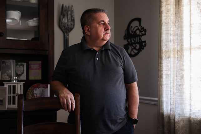 Man stares out window in own home