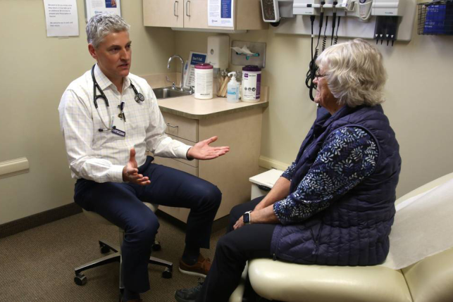 Doctor consulting elderly woman in exam room