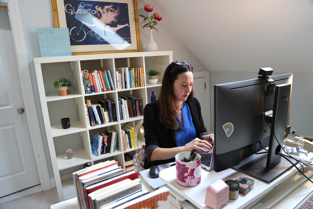 Woman sits at desk in home office