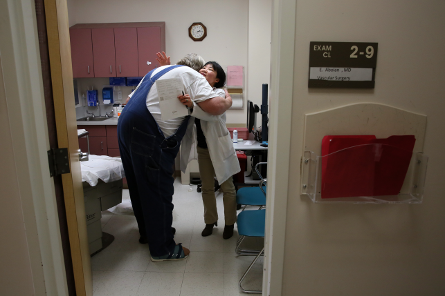 Elderly patient hugs nurse practitioner in doctors office