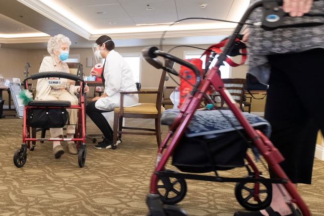 A CVS pharmacist intern talks with a resident at Emerald Court senior living community in Anaheim, CA on Friday, January 8, 2021 after giving the Pfizer/BioNTech COVID-19 vaccine.