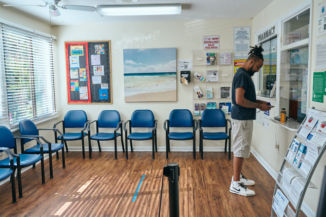 Man stands at check-in desk at waiting room