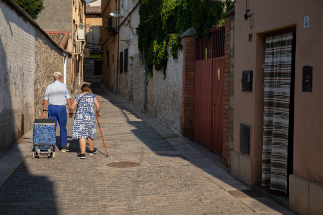 Elderly copy walks arm in arm through Spanish street