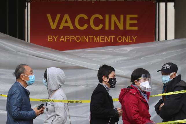 People with appointments stand in line to receive the COVID-19 vaccine at a vaccination site at Lincoln Park in East Los Angeles amid eased lockdown restrictions on January 28, 2021 in Los Angeles, California.