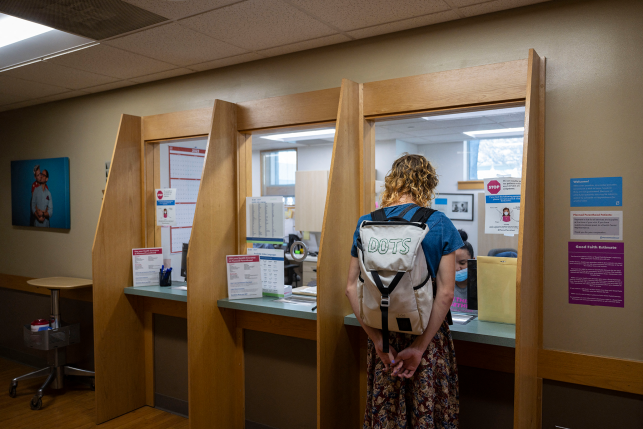 Woman with backpack checks in at clinic desk