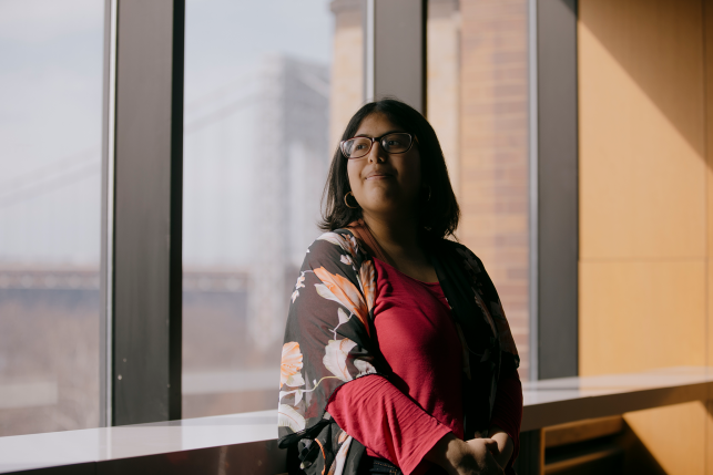 Woman looking in the distance in front of city scape.