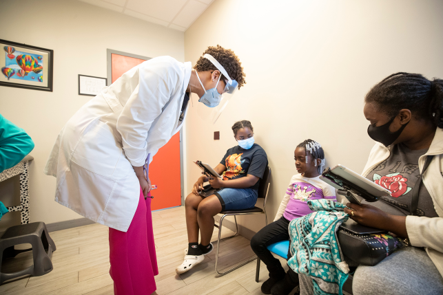 Doctor bends down to talk to child patient