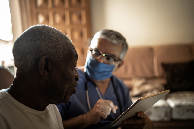 Health visitor and a senior man during home visit