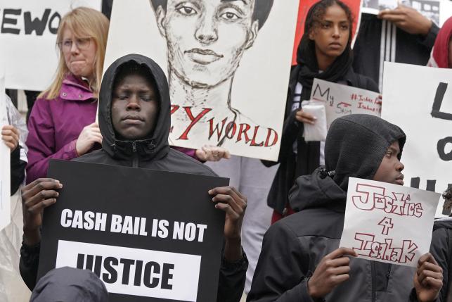 Cash bail protestors holding signs