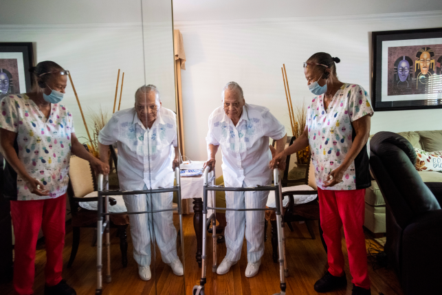 Elderly woman with walker is helped by a in-home nurse.