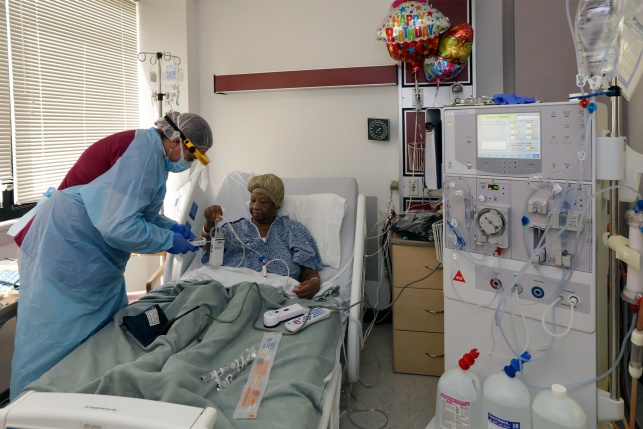 VICTORVILLE, CA - APRIL 29: Jennifer Stolpp, left, a dialysis nurse, prepares COVID-19 patient Janice Brown at Desert Valley Medical Group. Victorville, CA. (Irfan Khan / Los Angeles Times via Getty Images)
