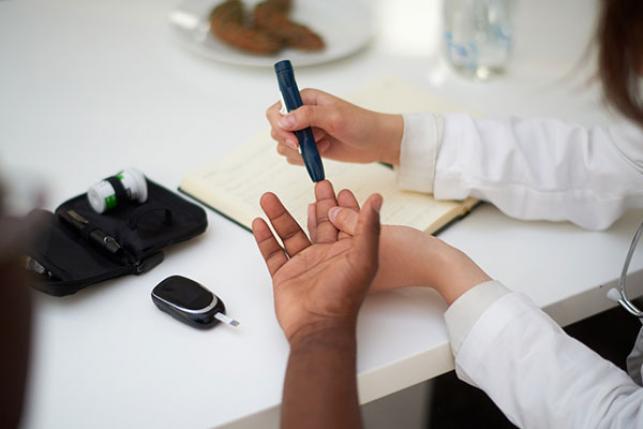doctor testing blood of diabetes patient