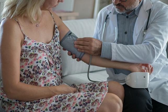 doctor taking patient's blood pressure