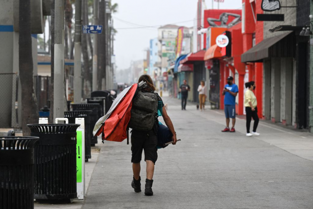 Man with backpack walks down empty street in LA